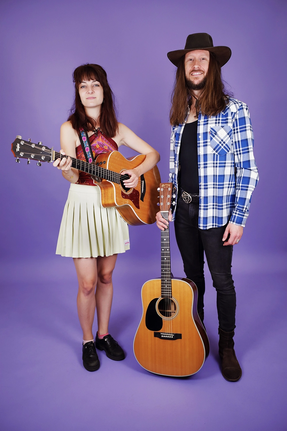 Duo de "Karoline and the Free Folks" en studio, avec des guitares sur fond violet.
