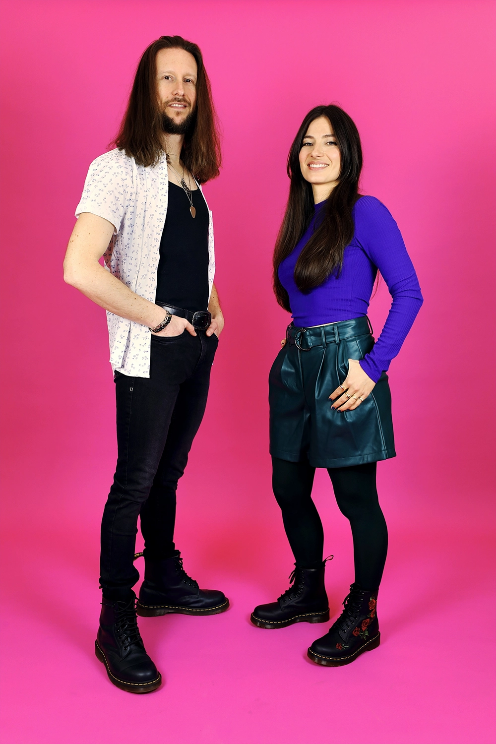 Homme et femme posant ensemble sur fond rose.