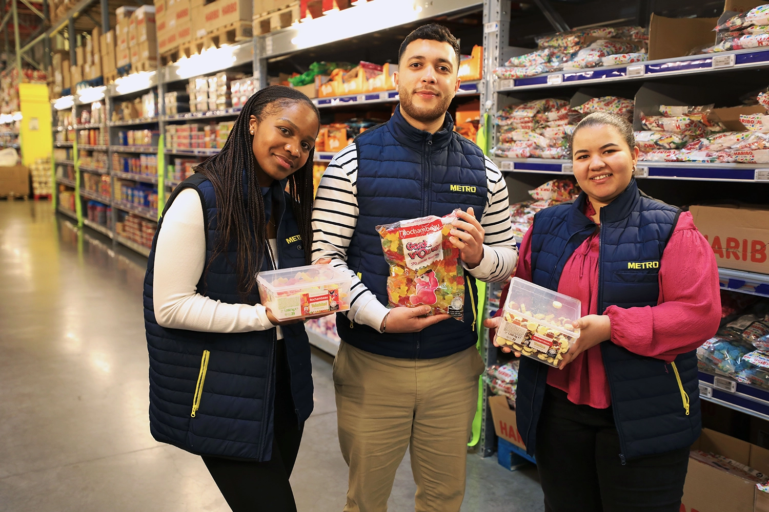 Trois alternants METRO posant avec des confiseries au rayon bonbons.