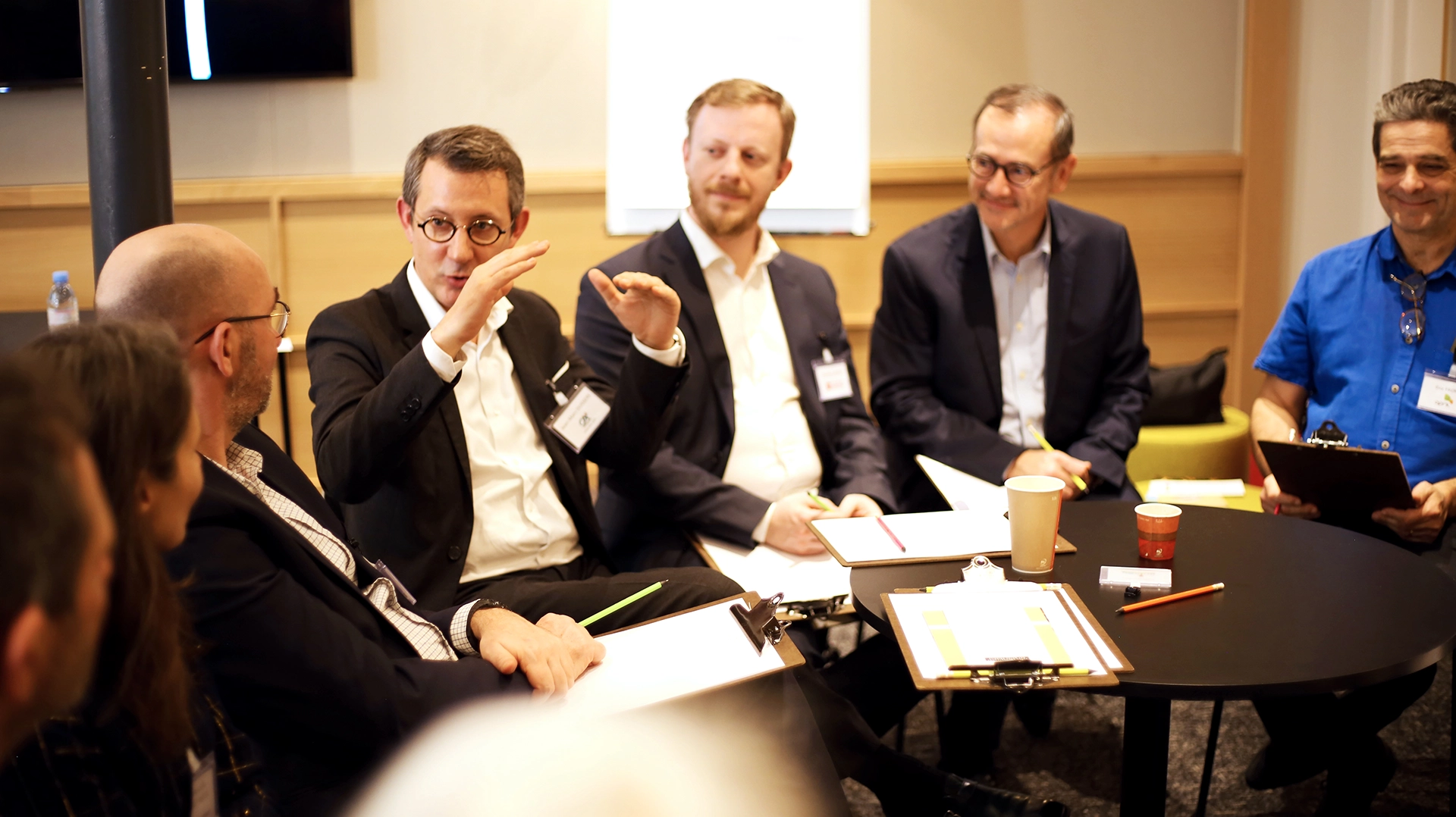 Participants attentifs dans un cercle de discussion lors d'un workshop sur les innovations professionnelles