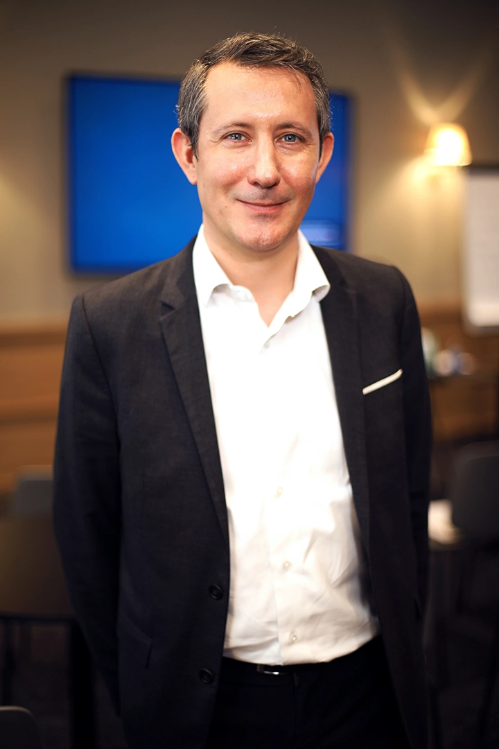 Portrait souriant d'un participant lors d'un workshop d'entreprises bancaires à Lyon, capturant un moment de connexion.