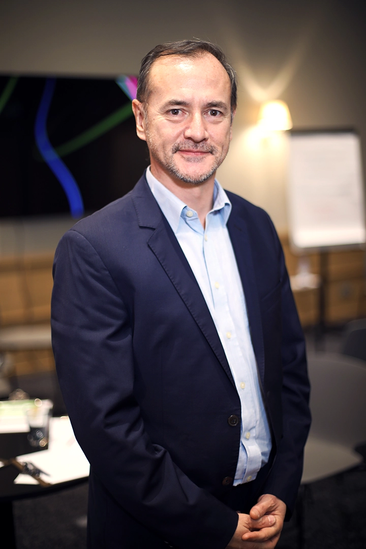 Portrait professionnel d'un participant souriant lors d'un workshop d'entreprises bancaires à Lyon, mettant en avant un cadre engageant.