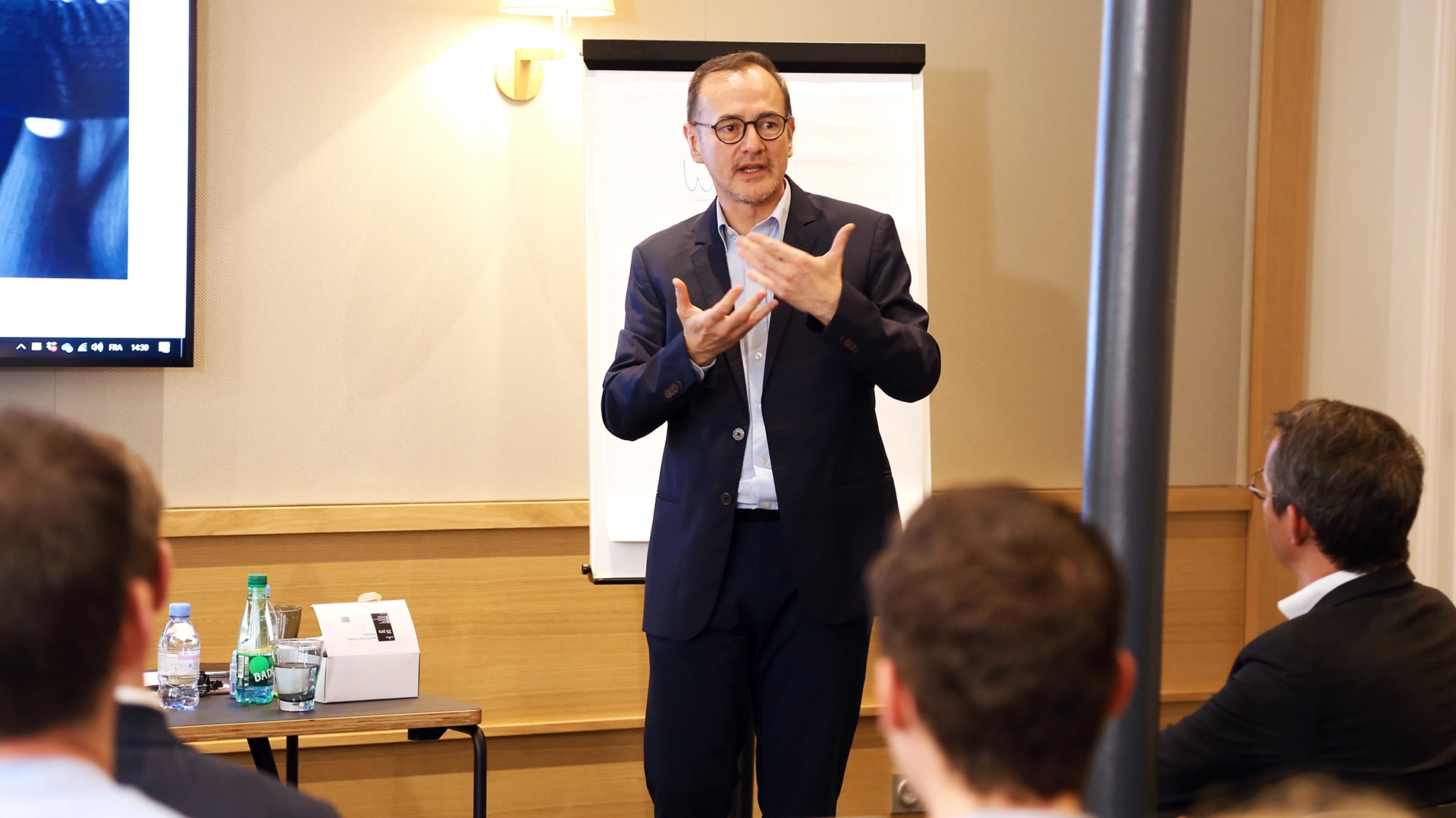 Photographie Corporate : Valorisez l'Image de Votre Entreprise Frédéric Maï, directeur de Conformitee, présentant lors d'un workshop inter-entreprises bancaires, s'adressant à un public attentif.