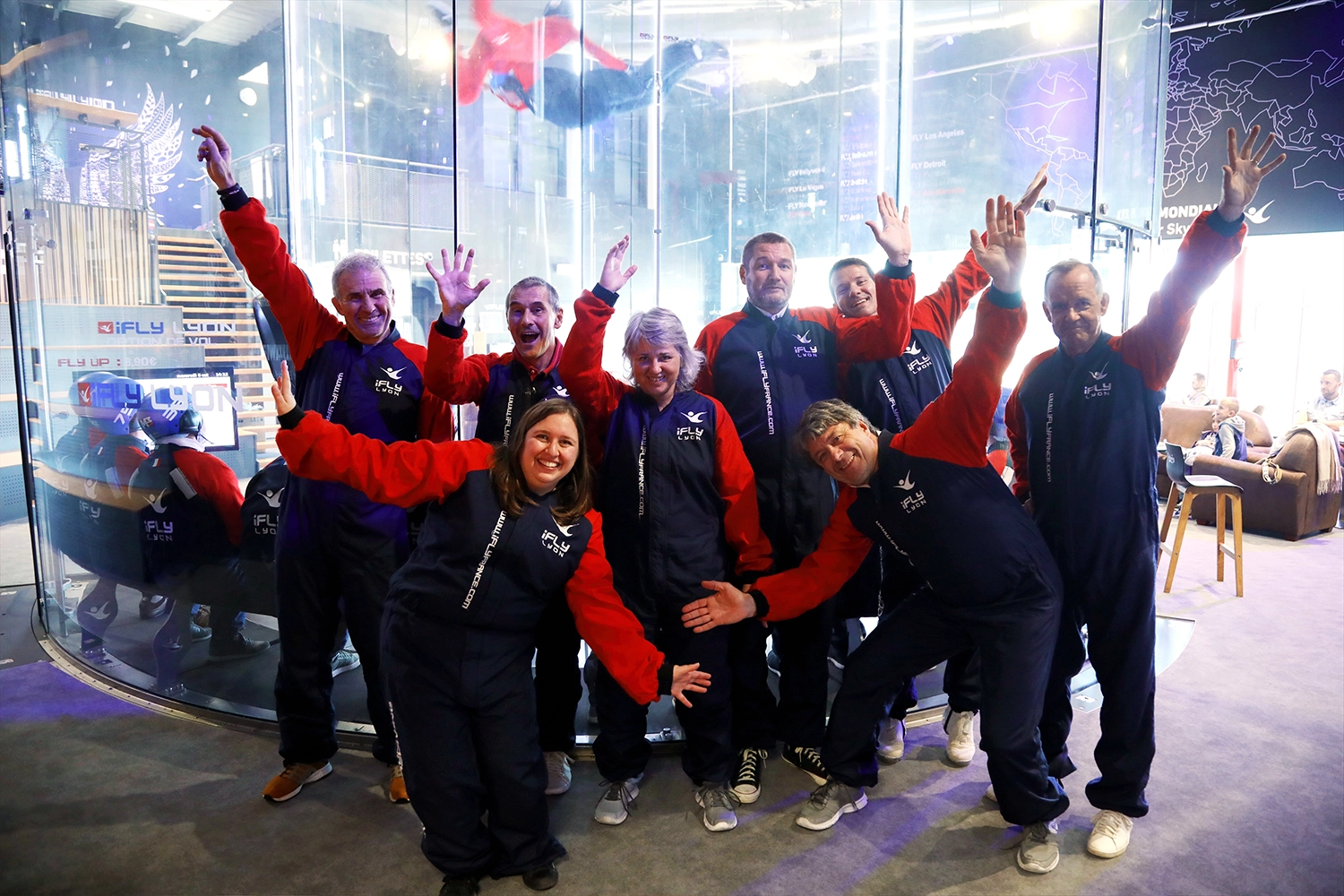 Équipe de participants enthousiastes à l'événement iFLY à Lyon, célébrant l'expérience de vol en soufflerie.