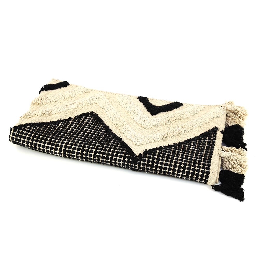 Tapis beige et noir avec motifs géométriques et franges, photographié pour Mondial Tissu.