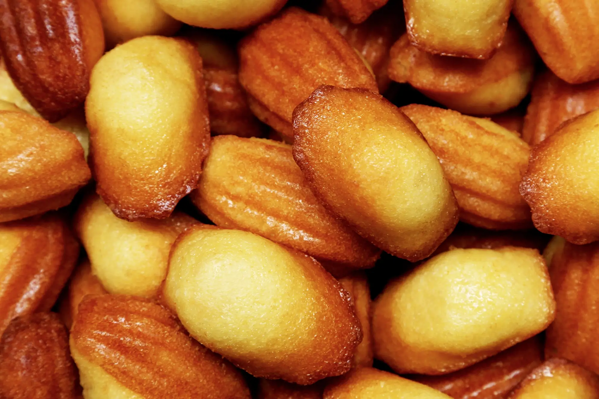 Photo studio promotionnelle des madeleines St Michel Biscuits Madeleines dorées de l'entreprise St Michel Biscuits, photographiées en gros plan sur un fond neutre.