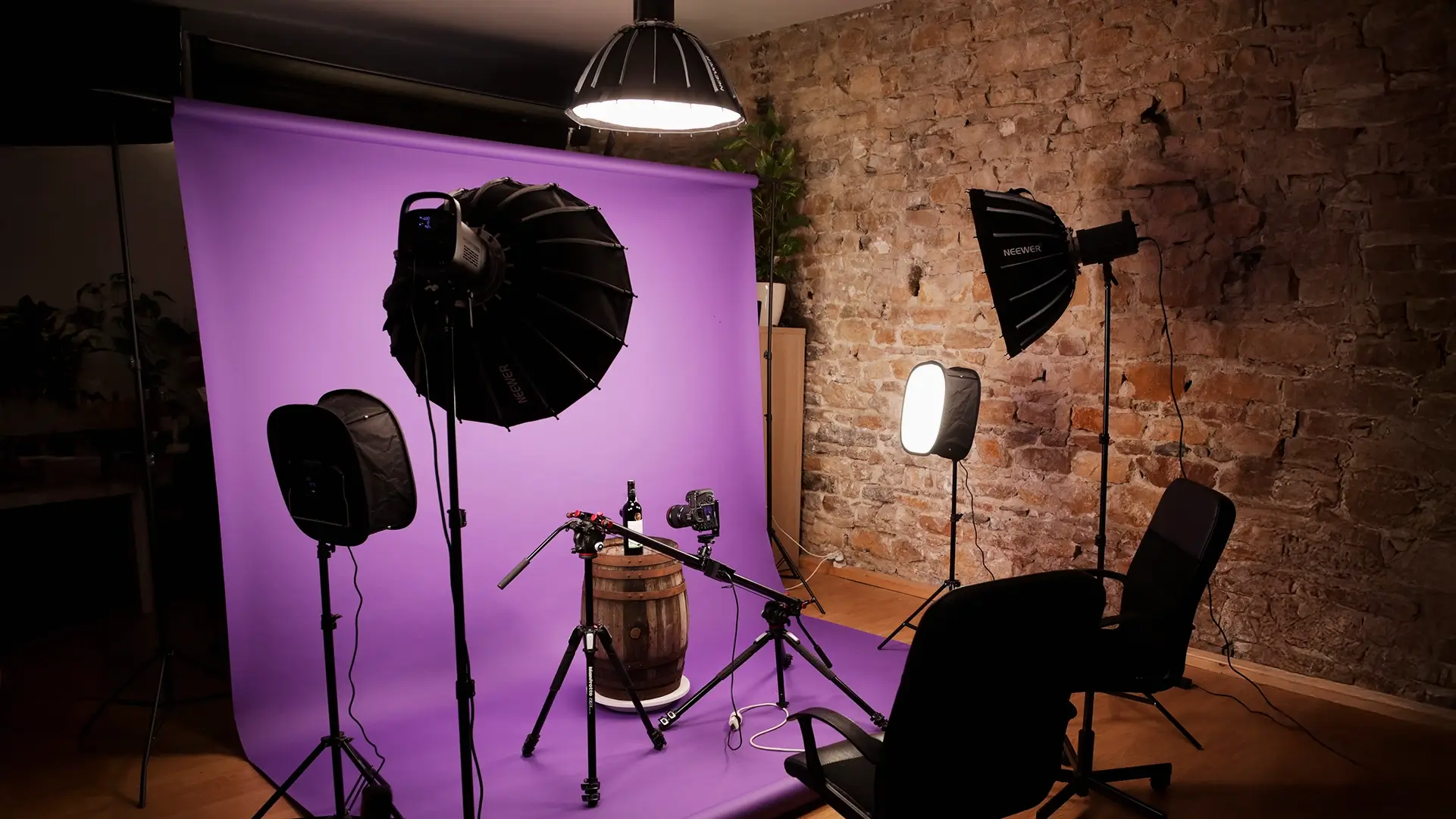 Découvrez notre studio photo à Lyon Studio photo de 50 m² avec un fond violet, équipé de plusieurs lumières et caméras pour la photographie professionnelle.