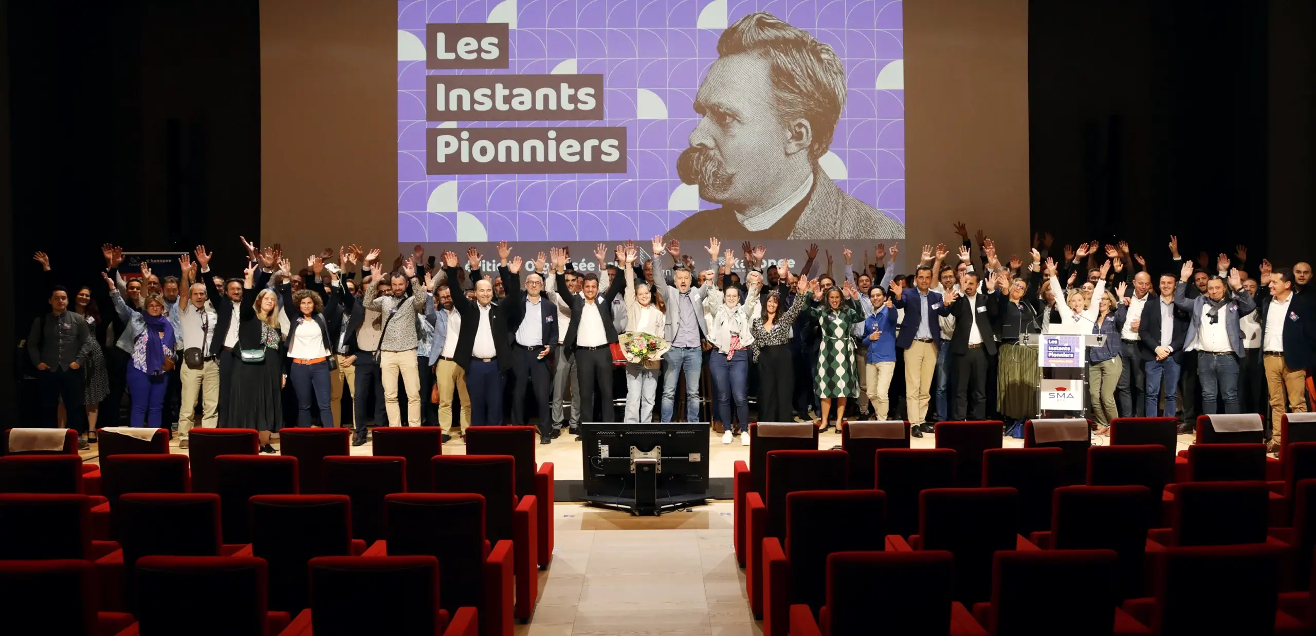 Événementiel : Les Instants Pionniers au SMA BTP à Paris Photo événementielle d'un groupe d'entrepreneurs levant les bras lors de l'événement 'Les Instants Pionniers' au SMA BTP, Paris.