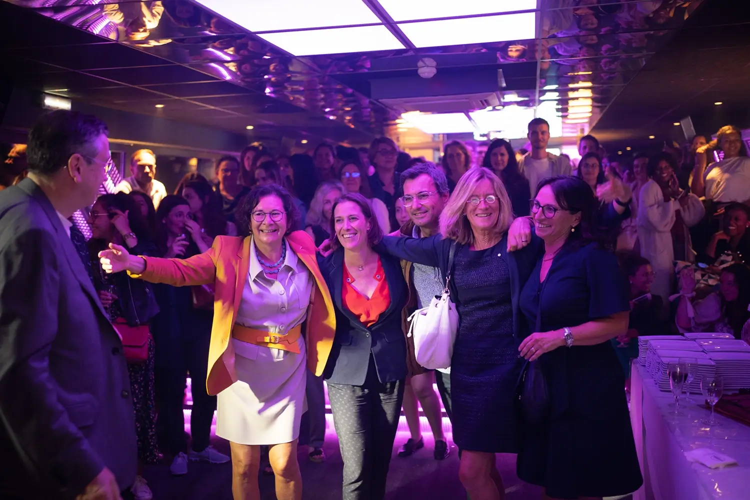 Soirée d’entreprise AplusA – invités Invités réunis sous des lumières violettes lors d’une soirée d’entreprise AplusA