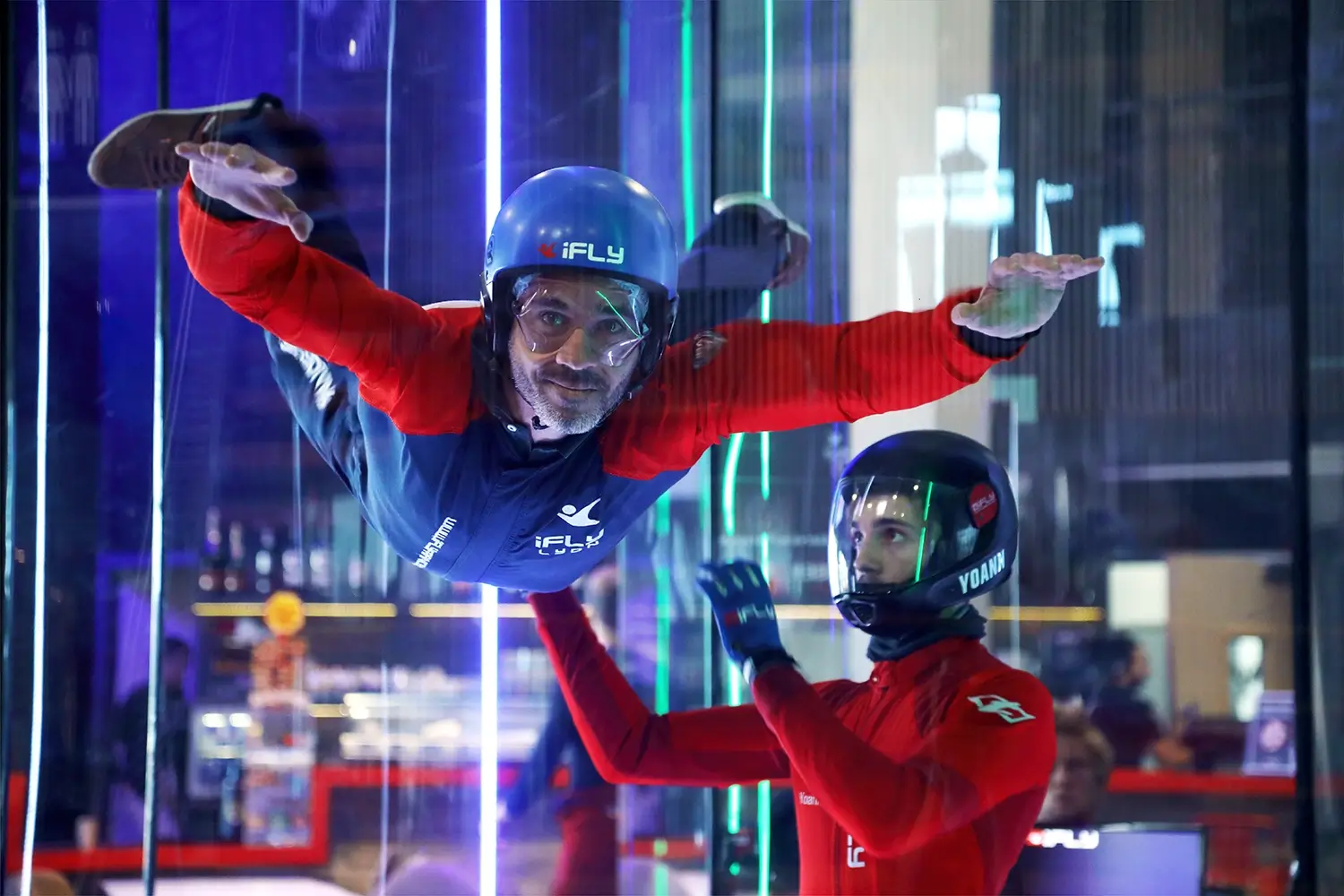 Cohésion d’équipe au iFly de Lyon-Bron – photo de groupe Un participant vole dans la soufflerie iFly accompagné d’un moniteur