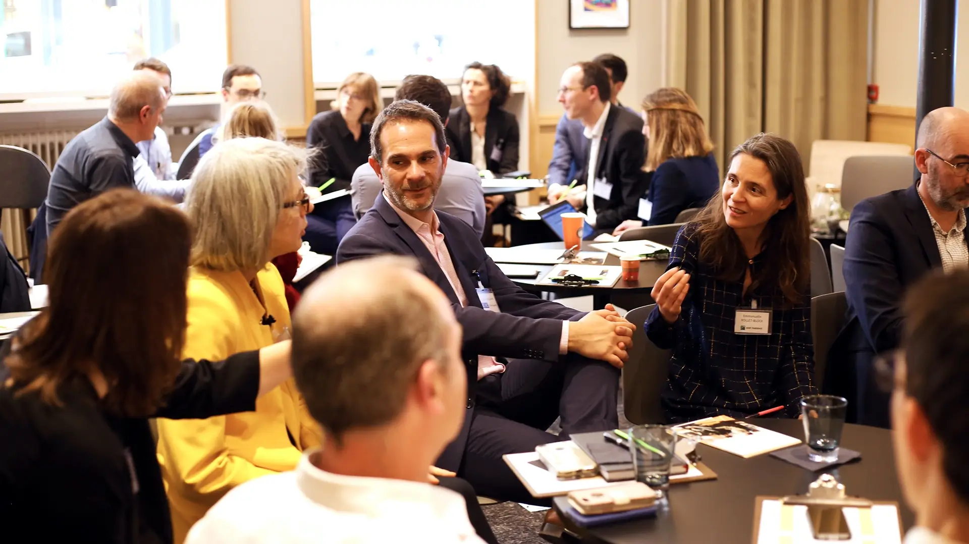 Séminaire professionnel – échanges en atelier Participants échangeant autour d’une table pendant un atelier professionnel