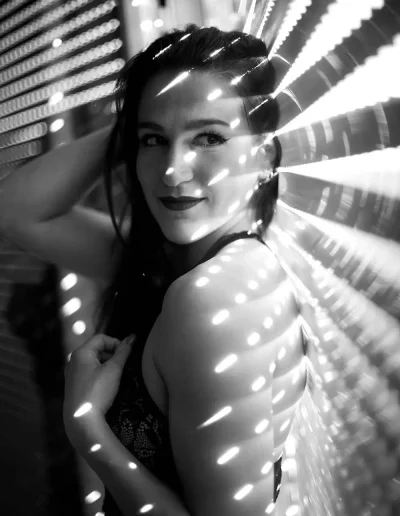 Portrait artistique en noir et blanc d’une femme traversée par des motifs lumineux.