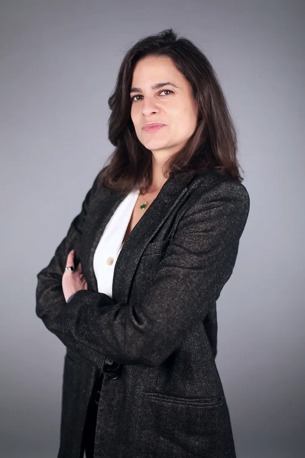 Portrait professionnel féminin sur fond gris Femme en veste sombre photographiée devant un fond gris uni pour un portrait professionnel.